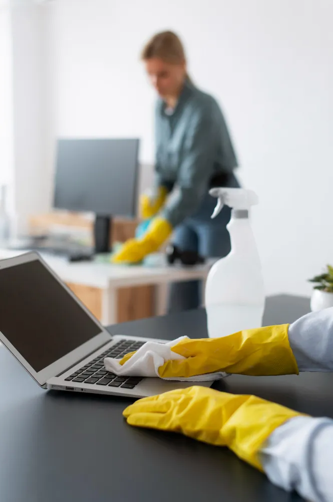 Someone cleaning a desk in the background.